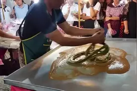 手工制作龙须糖，师傅拉得很费力，比拉面还要难