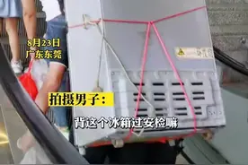 8月23日，广东东莞。男子背70斤冰箱赶火车过安检，好心路人帮忙上下肩，拍摄者：不舍得扔掉就自己背回去。视频封面