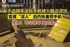 危险！上海一女子骑车看手机跌入泥坑图片
