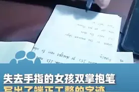 失去手指的女孩双掌抱笔写出了端正工整的字迹，“长大了想做老师 帮助像我这样的小朋友”图片